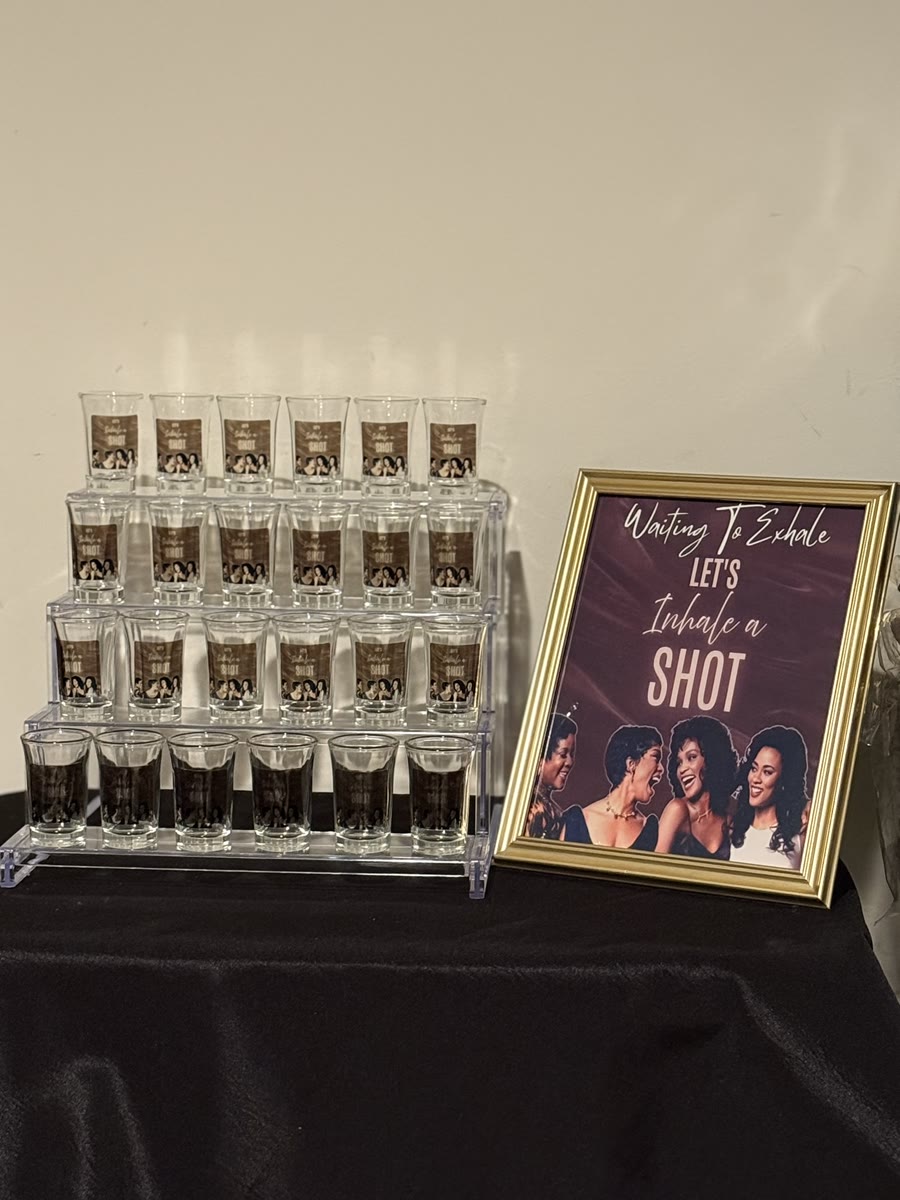 Custom shot glasses displayed with personalized photo labels for a celebration